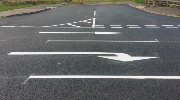 Highways team applying thermoplastic line markings on newly resurfaced road during a weekend closure.