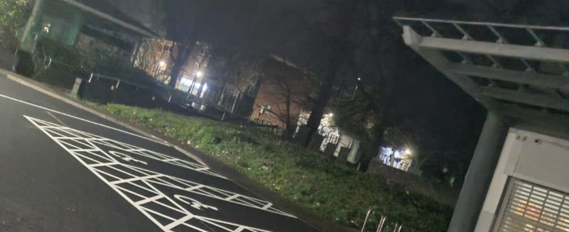 High-visibility parking bays, pedestrian walkways, and directional arrows marked on a newly surfaced retail car park.