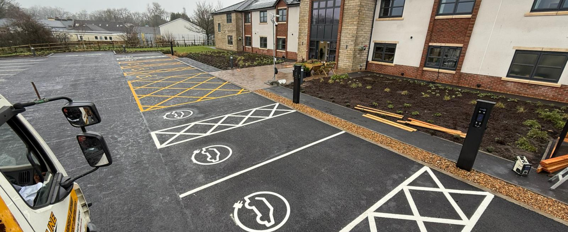 Painted EV parking bays outside a modern looking building
