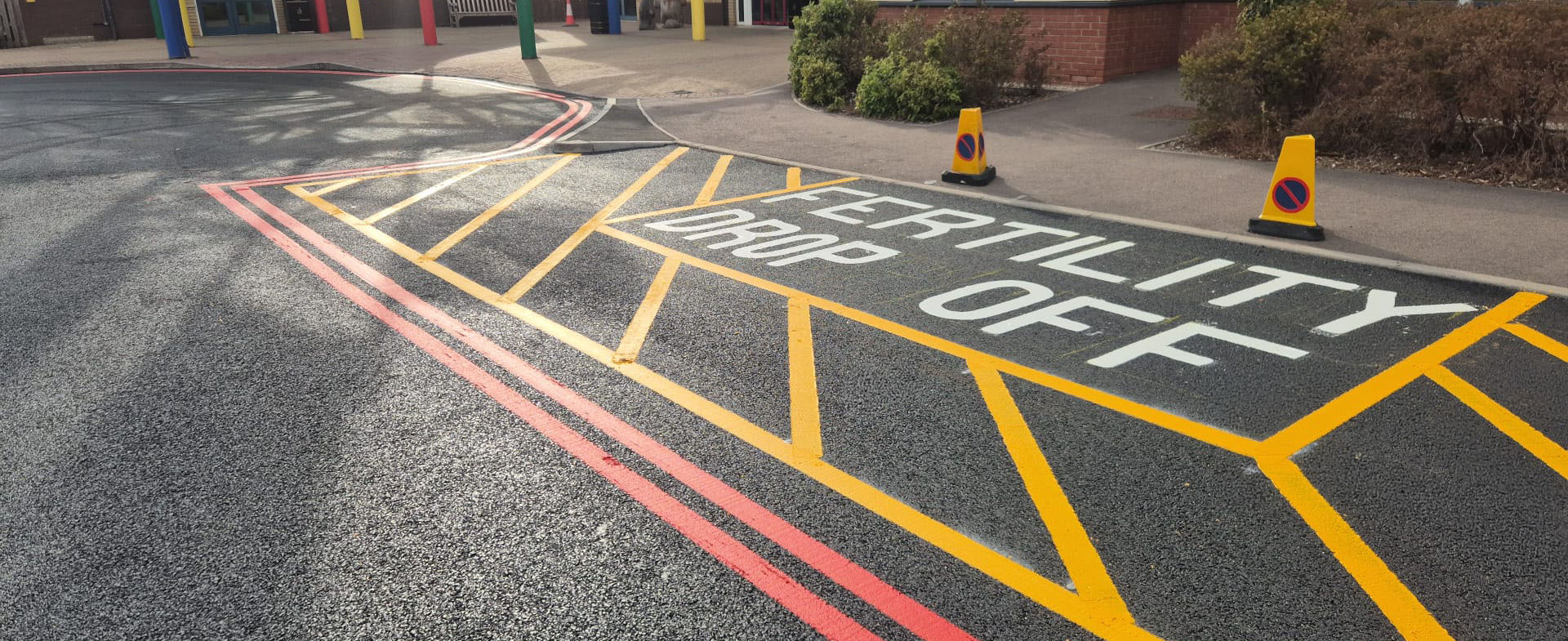 Newly applied parking bays, double red lines, yellow hatching and traffic markings on fresh tarmac at Royal Derby Hospital